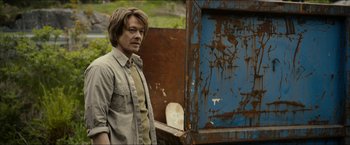 Movie still from “The Wave” (2015), directed by Roar Uthaug – A man standing in front of a rusted door; Medium shot, Over the shoulder angle