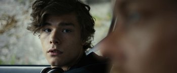 Movie still from “The Wave” (2015), directed by Roar Uthaug – A person wearing headphones; Close Up shot, Over the shoulder angle