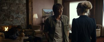Movie still from “The Wave” (2015), directed by Roar Uthaug – A man standing in front of a painting in a living room; Medium shot, Over the shoulder angle