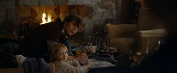 Movie still from “The Wave” (2015), directed by Roar Uthaug – A man and a little girl sitting in front of a fireplace; Medium shot, Over the shoulder angle