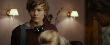 Movie still from “The Wave” (2015), directed by Roar Uthaug – A young man wearing headphones looking into a mirror; Close Up shot, Over the shoulder angle