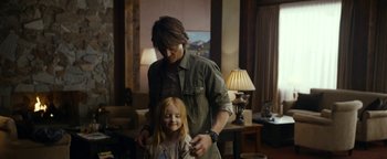 Movie still from “The Wave” (2015), directed by Roar Uthaug – A young girl getting her hair combed by a man; Medium shot, Over the shoulder angle