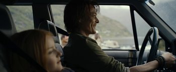Movie still from “The Wave” (2015), directed by Roar Uthaug – A man and a child in a car on a road; Medium shot, Over the shoulder angle