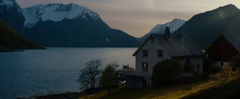 Movie still from “The Wave” (2015), directed by Roar Uthaug – A white house sitting next to a body of water; Extreme Wide shot, Low angle