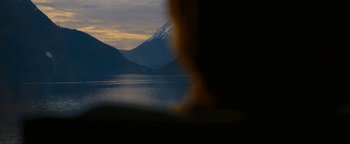 Movie still from “The Wave” (2015), directed by Roar Uthaug – A view of a body of water with a mountain in the background; Extreme Wide shot, Over the shoulder angle