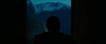 Movie still from “The Wave” (2015), directed by Roar Uthaug – A person sitting in front of a window at night; Medium shot, Low angle