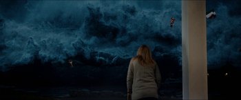 Movie still from “The Wave” (2015), directed by Roar Uthaug – A woman standing in front of an ocean wave; Extreme Wide shot, Over the shoulder angle