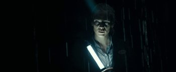 Movie still from “The Wave” (2015), directed by Roar Uthaug – A person wearing a reflective vest in a dark room; Close Up shot, Low angle