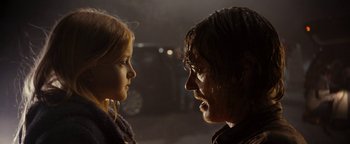 Movie still from “The Wave” (2015), directed by Roar Uthaug – A man and a girl face each other in a dark room; Close Up shot, Over the shoulder angle