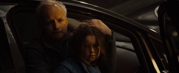Movie still from “The Wave” (2015), directed by Roar Uthaug – A man and a girl in the back seat of a car; Close Up shot, Over the shoulder angle