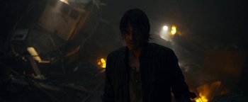 Movie still from “The Wave” (2015), directed by Roar Uthaug – A man standing in the dark in front of lights; Close Up shot, Over the shoulder angle