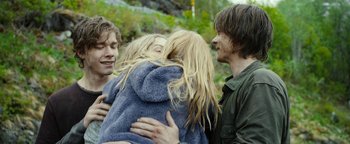 Movie still from “The Wave” (2015), directed by Roar Uthaug – A group of young people hugging each other in the woods; Medium shot, Over the shoulder angle