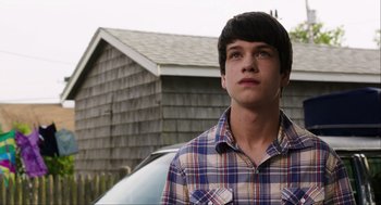 Movie still from “The Way Way Back” (2013), directed by Jim Rash – A young man standing in front of a car; Close Up shot, Over the shoulder angle