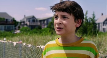 Movie still from “The Way Way Back” (2013), directed by Jim Rash – A boy in a striped shirt is looking at the camera; Close Up shot, Over the shoulder angle