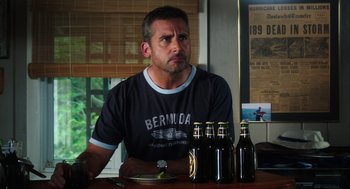 Movie still from “The Way Way Back” (2013), directed by Jim Rash – A man sitting at a table with several bottles of beer; Medium shot, Over the shoulder angle