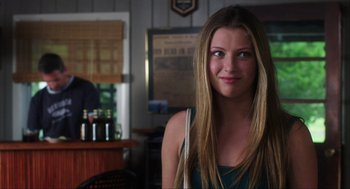 Movie still from “The Way Way Back” (2013), directed by Jim Rash – A beautiful young lady standing in front of a bar; Close Up shot, Over the shoulder angle
