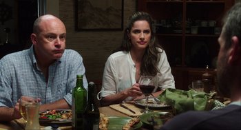 Movie still from “The Way Way Back” (2013), directed by Jim Rash – A woman sitting at a table with a glass of red wine; Medium shot, Over the shoulder angle
