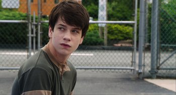Movie still from “The Way Way Back” (2013), directed by Jim Rash – A young man is standing in front of a chain link fence; Close Up shot, Over the shoulder angle