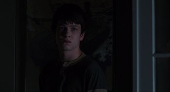 Movie still from “The Way Way Back” (2013), directed by Jim Rash – A young man standing in a dark room; Medium shot, Low angle