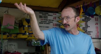 Movie still from “The Way Way Back” (2013), directed by Jim Rash – A man in a blue t - shirt is holding his arm up; Close Up shot, Low angle