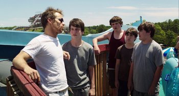 Movie still from “The Way Way Back” (2013), directed by Jim Rash – A group of young men standing next to each other on a deck; Medium shot, Over the shoulder angle