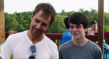 Movie still from “The Way Way Back” (2013), directed by Jim Rash – A man standing next to a young boy; Close Up shot, Over the shoulder angle