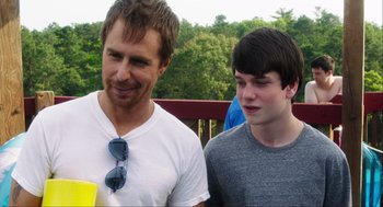 Movie still from “The Way Way Back” (2013), directed by Jim Rash – A man standing next to a young boy; Medium shot, Over the shoulder angle