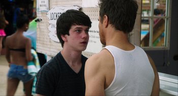 Movie still from “The Way Way Back” (2013), directed by Jim Rash – Two young men standing next to each other in front of a wall; Medium shot, Over the shoulder angle