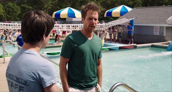 Movie still from “The Way Way Back” (2013), directed by Jim Rash – A man standing next to a swimming pool; Medium shot, Over the shoulder angle