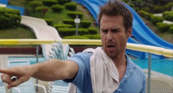 Movie still from “The Way Way Back” (2013), directed by Jim Rash – A man with a towel around his neck is holding his arm out; Close Up shot, Over the shoulder angle