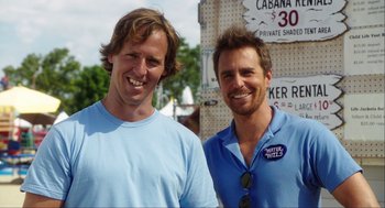 Movie still from “The Way Way Back” (2013), directed by Jim Rash – A couple of men standing next to each other; Medium shot, Overhead angle