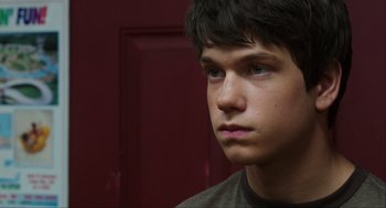Movie still from “The Way Way Back” (2013), directed by Jim Rash – A young man with a serious look on his face; Close Up shot, Over the shoulder angle