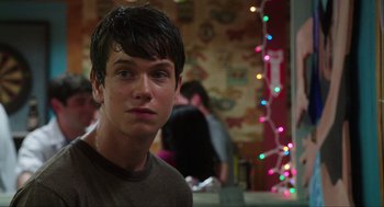 Movie still from “The Way Way Back” (2013), directed by Jim Rash – A young man is standing in front of christmas lights; Close Up shot, Over the shoulder angle