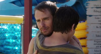 Movie still from “The Way Way Back” (2013), directed by Jim Rash – A person holding a child; Close Up shot, Over the shoulder angle