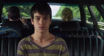 Movie still from “The Way Way Back” (2013), directed by Jim Rash – A young man sitting in the back seat of a car; Close Up shot, Over the shoulder angle