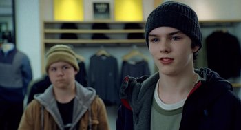 Movie still from “The Weather Man” (2005), directed by Gore Verbinski – Two young men are standing in front of a row of jackets; Close Up shot, Over the shoulder angle