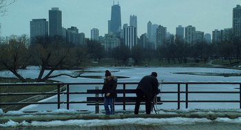 Movie still from “The Weather Man” (2005), directed by Gore Verbinski – Two people sitting on a bench in front of a city skyline; Extreme Wide shot, High angle