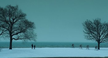 Movie still from “The Weather Man” (2005), directed by Gore Verbinski – Two people are walking on the snow near the water; Extreme Wide shot, High angle