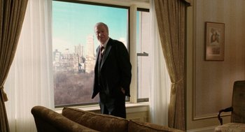 Movie still from “The Weather Man” (2005), directed by Gore Verbinski – An older man standing in front of a large window; Wide shot, Over the shoulder angle
