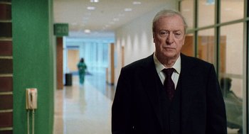 Movie still from “The Weather Man” (2005), directed by Gore Verbinski – An older man wearing a suit and tie in an office hallway; Medium shot, Over the shoulder angle
