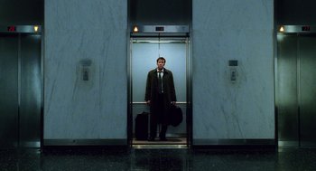 Movie still from “The Weather Man” (2005), directed by Gore Verbinski – A man standing in an elevator holding a suitcase; Wide shot, Low angle