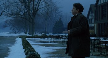 Movie still from “The Weather Man” (2005), directed by Gore Verbinski – A man smoking a cigarette while standing in the snow; Medium shot, Low angle