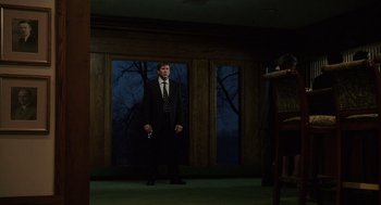 Movie still from “The Weather Man” (2005), directed by Gore Verbinski – A man in a suit and tie holding a gun; Wide shot, Low angle