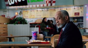 Movie still from “The Weather Man” (2005), directed by Gore Verbinski – An older man sitting in front of a tray of food; Medium shot, High angle