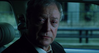 Movie still from “The Weather Man” (2005), directed by Gore Verbinski – An older man sitting in the back seat of a car; Close Up shot, Over the shoulder angle