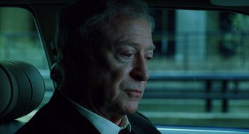 Movie still from “The Weather Man” (2005), directed by Gore Verbinski – An older man sitting in the back of a car; Close Up shot, Over the shoulder angle