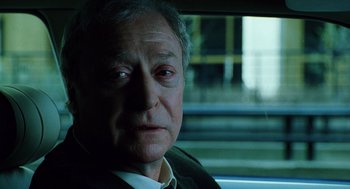 Movie still from “The Weather Man” (2005), directed by Gore Verbinski – An older man sitting in the back seat of a car; Close Up shot, Over the shoulder angle