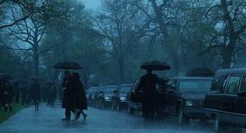 Movie still from “The Weather Man” (2005), directed by Gore Verbinski – Two people walking in the rain holding umbrellas; Wide shot, Low angle
