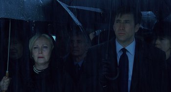 Movie still from “The Weather Man” (2005), directed by Gore Verbinski – A group of people standing next to each other under an umbrella; Close Up shot, Low angle
