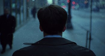 Movie still from “The Weather Man” (2005), directed by Gore Verbinski – A man wearing a suit and tie standing in the snow; Close Up shot, Over the shoulder angle